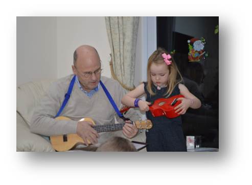 A photo of my father in law Gary teaching Emily a little ditty on the Ukulele