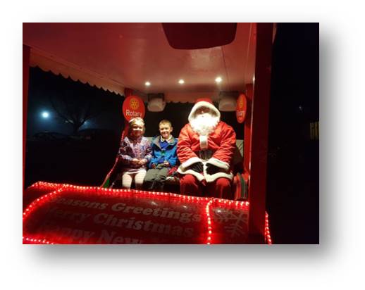The kids posing with Santa on the Rotary Club sleigh.