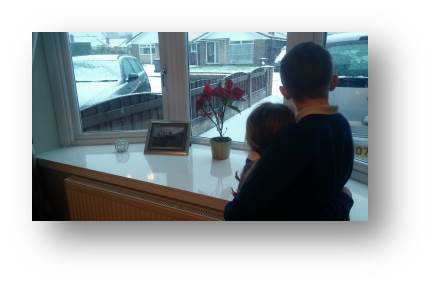 Adam and Emily looking out on the slush wishing it was proper snow.