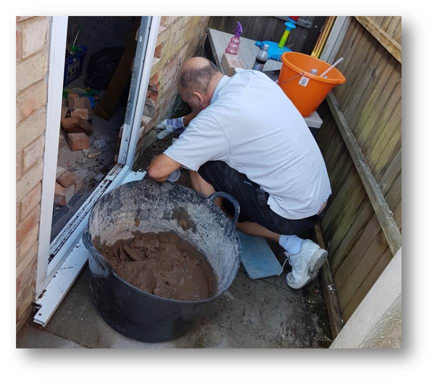 Gary repairing the half-brick gaps Ive left in the front and sides when ive put the door in around the back of the garage